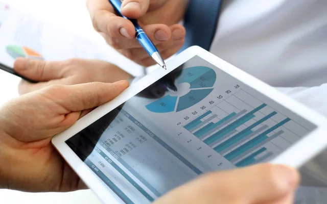 Analyst reviewing charts and KPIs on a tablet dashboard