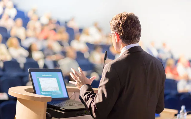 Speaker presenting to an audience at a conference