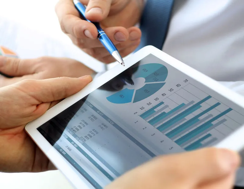 Analyst reviewing charts and KPIs on a tablet dashboard