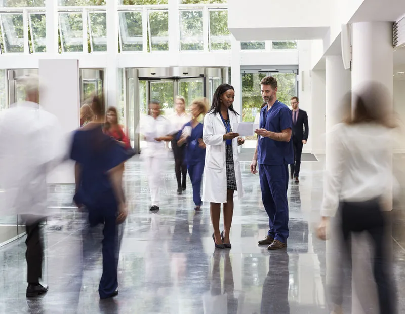 Clinical and administrative staff in a modern hospital lobby