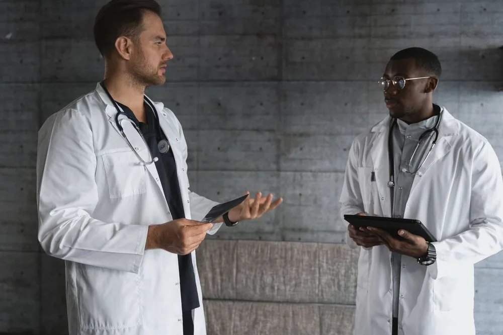 Two hospital clinicians comparing notes on a tablet